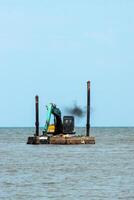 machines zijn baggeren zand in de zee. foto