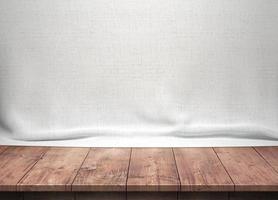 houten tafel met witte katoenen stof achtergrond foto