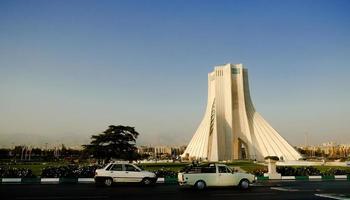 teheran, iran, 2016 - azadi-toren of shahyad-toren bij zonsondergang met zichtbaar stof en luchtvervuiling in de stad. foto