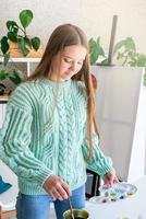 jonge tienervrouw die een kleurenpalet vasthoudt en in haar studio werkt