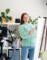 jonge tienervrouw die een kleurenpalet vasthoudt en in haar studio werkt foto