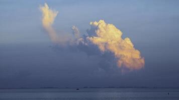 visie van de groot wolk bovenstaand de zee Bij de zonsondergang. schot. mooi zonsondergang bovenstaand de zee en wit wolken Aan de horizon foto