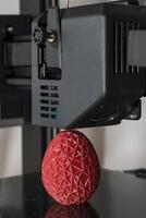 dichtbij omhoog van een 3d printer het drukken een rood veelhoekige ei foto