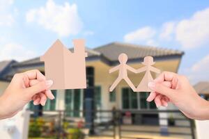 handen Holding familie papieren Aan huis achtergrond. foto