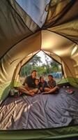 ai generatief gelukkig familie camping in de Woud nemen selfie portret samen moeder vader en zoon hebben pret trekking in de natuur zittend in voorkant van de tent familie natuur en trekking foto