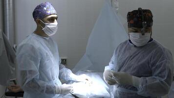 medisch team het uitvoeren van chirurgisch operatie in helder modern in werking kamer. actie. verpleegster assisteren gedurende chirurgie. foto