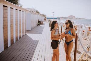 glimlachen jong Dames in bikini genieten van vakantie Aan de strand foto