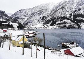 winterlandschapsdorp aan de rivier van het fjordmeer in framfjorden, noorwegen. foto