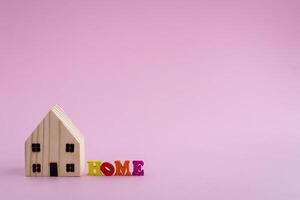 houten huis model- met huis alfabet Aan roze achtergrond foto