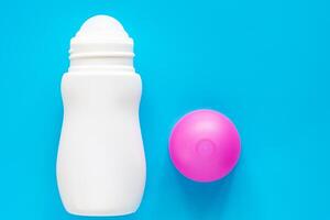 vrouw deodorant of rollen Aan fles met roze Hoes Aan blauw achtergrond foto