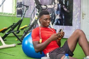 opgewonden Mens in de Sportschool in werking zijn telefoon foto