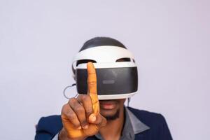 versteld staan jong Mens spelen video spellen in vr stofbril of 3d bril, vervelend virtueel realiteit koptelefoon voor Aan zijn hoofd foto