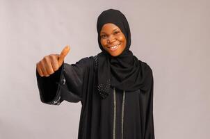 dichtbij omhoog van mooi Afrikaanse moslim dame glimlachen net zo ze deed duimen omhoog foto