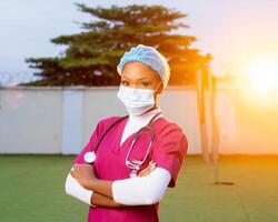 portret van jong volwassen vrouw dokter of verpleegster vervelend scrubs en stethoscoop buiten. foto