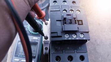 controle magnetisch contactor terminals gebruik makend van een multimeter, magnetisch contactor elektrisch controle componenten. terminals verbinding bedrading controleren. foto