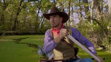 een cowboy in een rood kano drijft Aan groen rivier- in de Woud. historisch wederopbouw van leven in de wild west van Amerika. foto