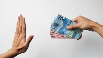 handen zijn geven en afwijzen Indonesisch geld. concept van sharing geld voor steekpenningen foto