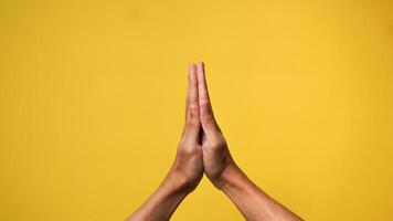Mannen handen bidden en bedelen god voor vergiffenis Aan een geel achtergrond foto