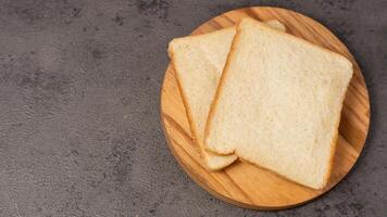 plakjes van wit brood Aan een houten bord foto