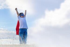 kind jongen hebben pret buitenshuis, weinig kind Speel superheld, gelukkig speels kinderen spelen buitenshuis foto