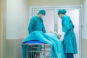 selectief focus van medisch team in beweging een geduldig naar chirurgie in de in werking kamer Bij de ziekenhuis foto