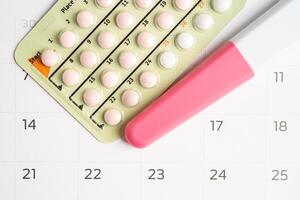 zwangerschap test en geboorte controle pillen Aan kalender, anticonceptie Gezondheid en geneesmiddel. foto