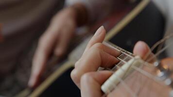 close-up van de hand van jonge gemengd ras vrouw tuners op kop van gitaar aan te passen foto