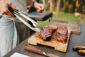 een Mens Aan de straat gekookt een steak Aan de rooster in een barbecue foto