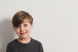 portret van schattige jongen die gezichten trekt foto