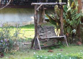 oud houten schommel in de tuin foto