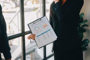 co-werkconferentie, zakelijke teamvergadering aanwezig, investeerderscollega's bespreken nieuw plan financiële grafiekgegevens op kantoortafel met laptop en digitale tablet, financiën, boekhouding, investeringen. foto