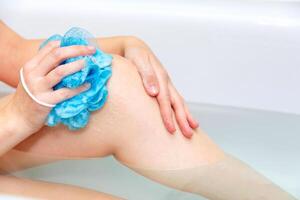 vrouw het wassen haar lichaam in de bad. detailopname van vrouw poten in een bad foto
