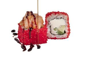 sushi is gerold in rood kunstmatig kaviaar met rijst, Philadelphia kaas en gegoten met soja saus. sushi Aan een wit achtergrond detailopname. foto