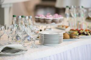 buffet tafel met gerechten en snacks.a stack van wit borden Aan de tafel van de buffet tafel foto