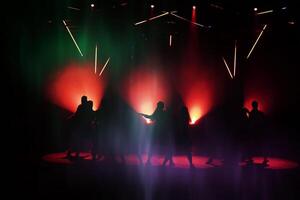 donker silhouetten van dansen mensen tegen de achtergrond van de lazar licht lichten van de fase. foto