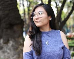 jonge vrouw in openbaar park met bril kijkt zijwaarts foto