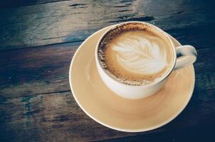 koffie latte kop Aan een hout tafel foto