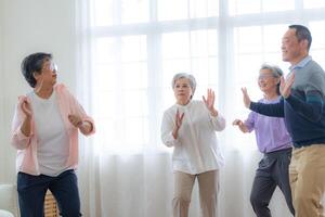 Aziatisch ouder mannetje en vrouwtjes mensen dans met hun partners Aan een dansen verdieping in leven ruimte. gelukkig ouder paar het uitvoeren van krijgen oefening. blij zorgeloos gepensioneerd senior vrienden genieten van ontspanning foto