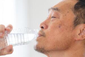 geluk van mannetje ouderen Holding een fles van water. senior mensen drinken vers mineraal water. foto