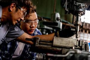 Aziatisch arbeider in productie fabriek boren Bij machine. professioneel arbeider in de buurt boren machine Aan fabriek. afwerking metaal werken intern staal oppervlakte Aan draaibank Slijper machine met vliegend vonken. foto