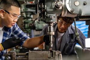 Aziatisch arbeider in productie fabriek boren Bij machine. professioneel arbeider in de buurt boren machine Aan fabriek. afwerking metaal werken intern staal oppervlakte Aan draaibank Slijper machine met vliegend vonken. foto