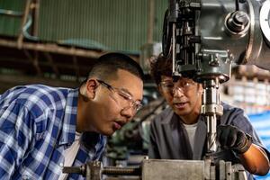 Aziatisch arbeider in productie fabriek boren Bij machine. professioneel arbeider in de buurt boren machine Aan fabriek. afwerking metaal werken intern staal oppervlakte Aan draaibank Slijper machine met vliegend vonken. foto