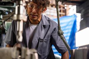 Aziatisch arbeider in productie fabriek boren Bij machine. professioneel arbeider in de buurt boren machine Aan fabriek. afwerking metaal werken intern staal oppervlakte Aan draaibank Slijper machine met vliegend vonken. foto