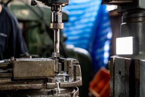 dichtbij omhoog metaal boren beetje blijven positie voor maken gaten in staal gietvorm. metaal industrie. frezen werkwijze met metaal bord onderdelen Aan cnc frezen machine. winkel verdieping frezen operatie door frezen machine. foto