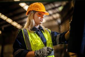 fabriek ingenieur vrouw staand vertrouwen naar controle paneel schakelaar. arbeider werken Bij zwaar machine Bij industrie fabriek. met machinerie uitrusting fabriek technologie. slim industrie arbeider werkend. foto