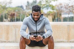 zwart sportman browsen mobiele telefoon Aan trap foto