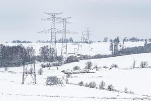 bouw van hoog Spanning pylonen in winter. gemonteerd macht transmissie lijn ondersteunt, klaar voor installatie. foto