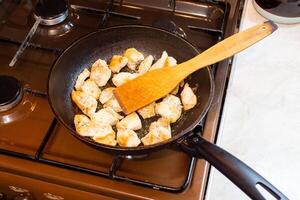 kip borsten vlees enkel en alleen Aan frituren pan en houten spatel, huiselijk gezond keuken, echt leven situatie. foto