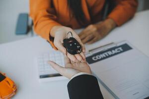 detailopname Aziatisch mannetje mensen auto verkoper of verkoop manager aanbiedingen naar verkopen een auto en legt uit en leest de voorwaarden van ondertekening een auto contract en verzekering. foto