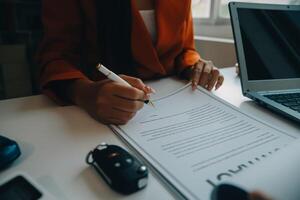 detailopname Aziatisch mannetje mensen auto verkoper of verkoop manager aanbiedingen naar verkopen een auto en legt uit en leest de voorwaarden van ondertekening een auto contract en verzekering. foto